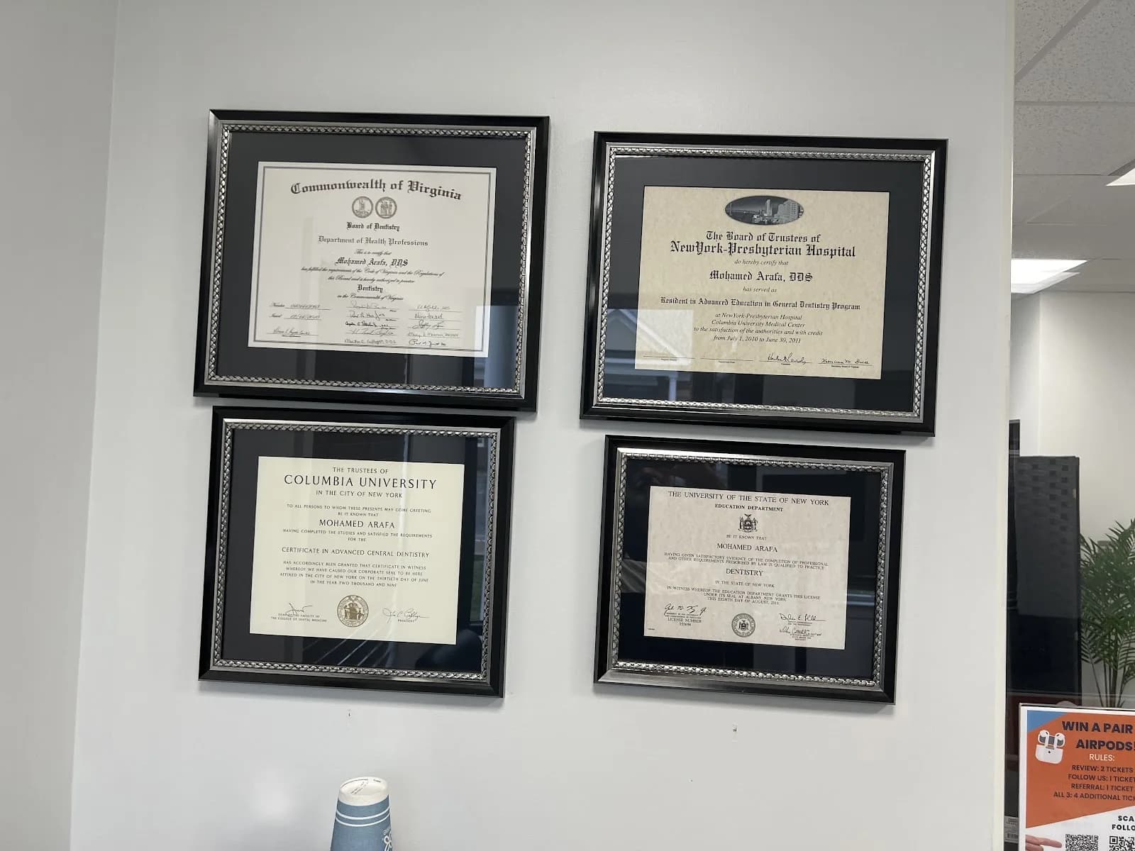 Framed diplomas and certificates on the office wall